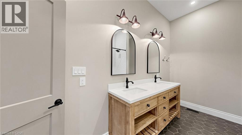 Dual vanity with white countertop, black fixtures, and wood-finish cabinetry - 41 Talbot Road, Delhi, ON - Indoor Photo Showing Bathroom