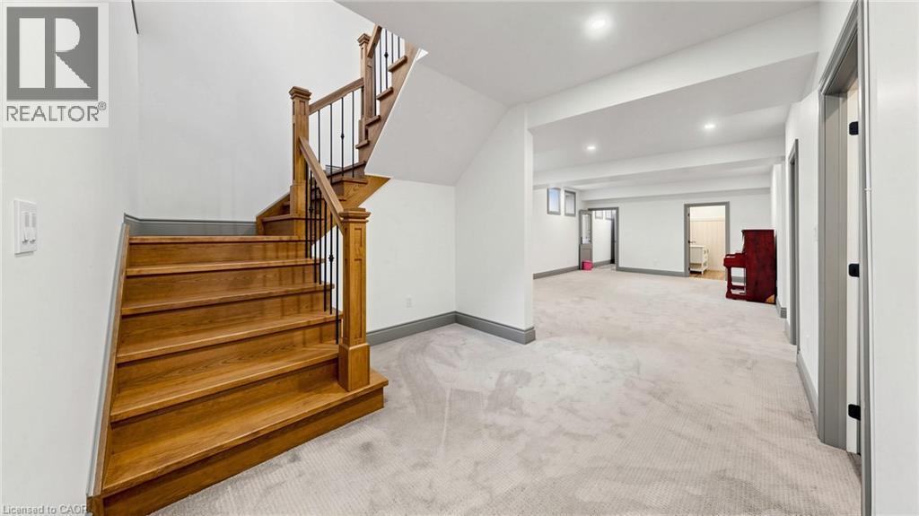 Staircase featuring wood treads, wood newel post, and black iron balusters - 41 Talbot Road, Delhi, ON - Indoor Photo Showing Other Room