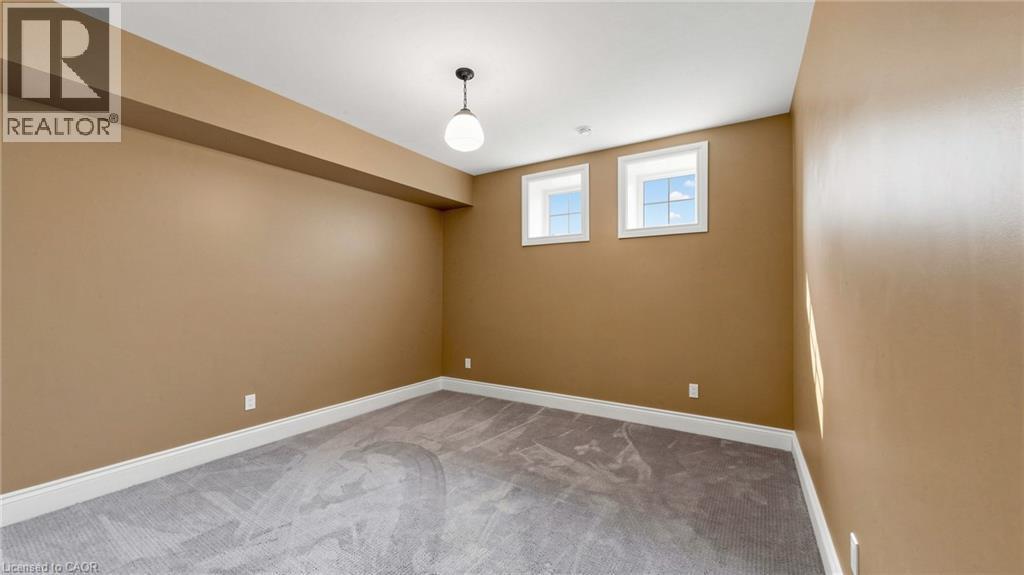 Room featuring two transom windows, light-colored carpeting, and a built-in soffit - 41 Talbot Road, Delhi, ON - Indoor Photo Showing Other Room