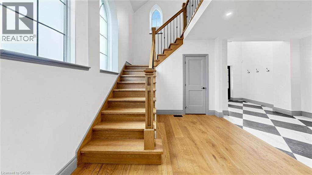 Grand staircase with natural wood treads and wrought iron balusters - 41 Talbot Road, Delhi, ON - Indoor Photo Showing Other Room