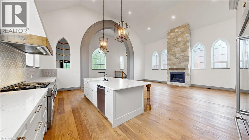 Open-concept living area with vaulted ceilings, natural wood-finish flooring, and arched windows - 41 Talbot Road, Delhi, ON - Indoor Photo Showing Kitchen With Fireplace With Upgraded Kitchen