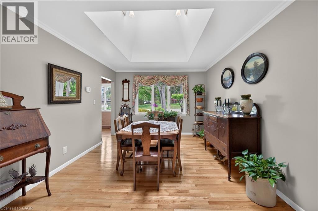 Dining area featuring a large central skylight, hardwood flooring, and neutral wall tones - 2 Summit Circle, Simcoe, ON - Indoor Photo Showing Dining Room