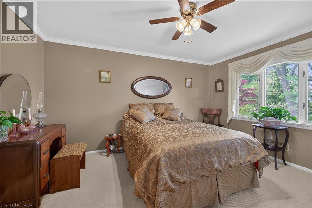 Neutral-toned walls with white crown molding and carpeted flooring - 2 Summit Circle, Simcoe, ON - Indoor Photo Showing Bedroom