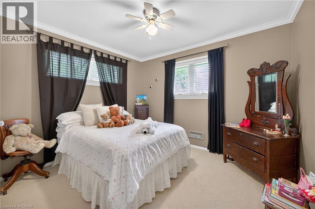Carpeted bedroom featuring neutral-toned walls and white crown molding - 2 Summit Circle, Simcoe, ON - Indoor Photo Showing Bedroom