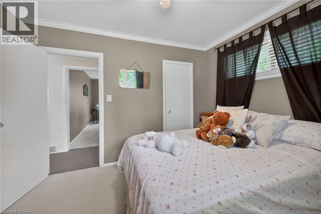 Bedroom featuring neutral wall paint, crown molding, white doors, and light-colored carpet flooring - 2 Summit Circle, Simcoe, ON - Indoor Photo Showing Bedroom