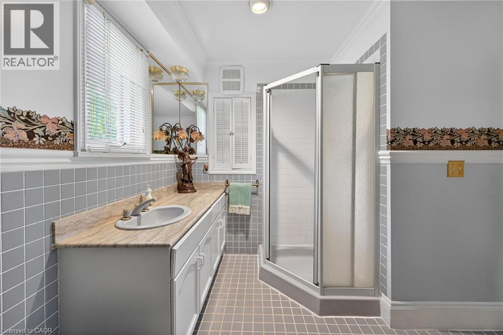 Bathroom featuring a single vanity with an integrated sink and stone countertop - 2 Summit Circle, Simcoe, ON - Indoor Photo Showing Bathroom