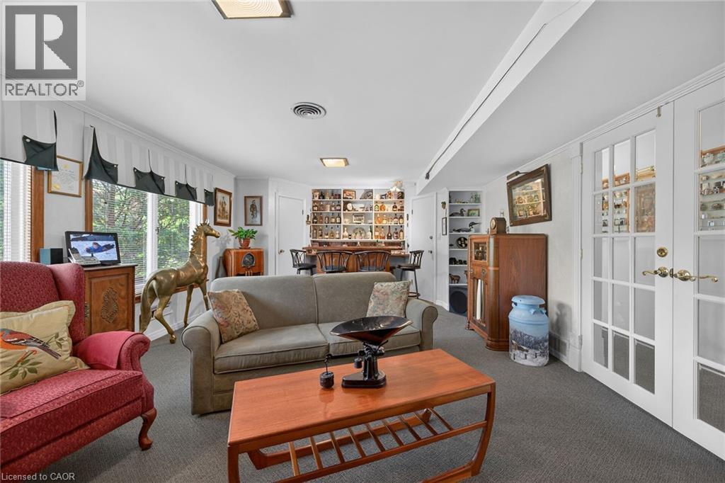 Carpeted living area featuring a large window, recessed lighting, and a built-in bar with shelving - 2 Summit Circle, Simcoe, ON - Indoor Photo Showing Living Room