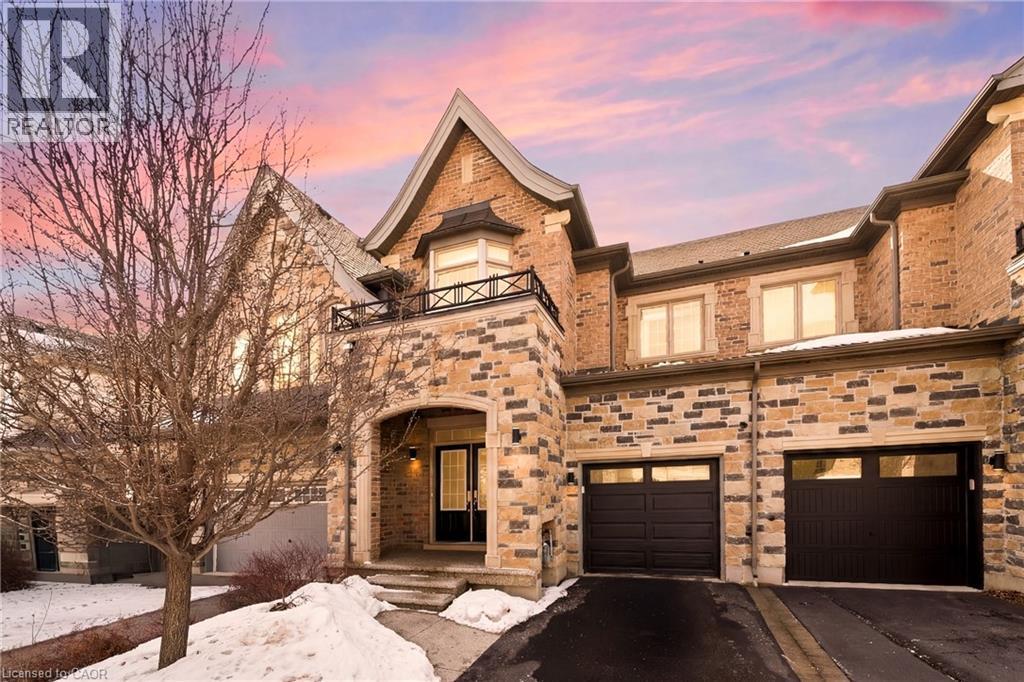 Stone and brick facade with a prominent arched entry - 2466 Village Common, Oakville, ON - Outdoor With Fireplace With Facade