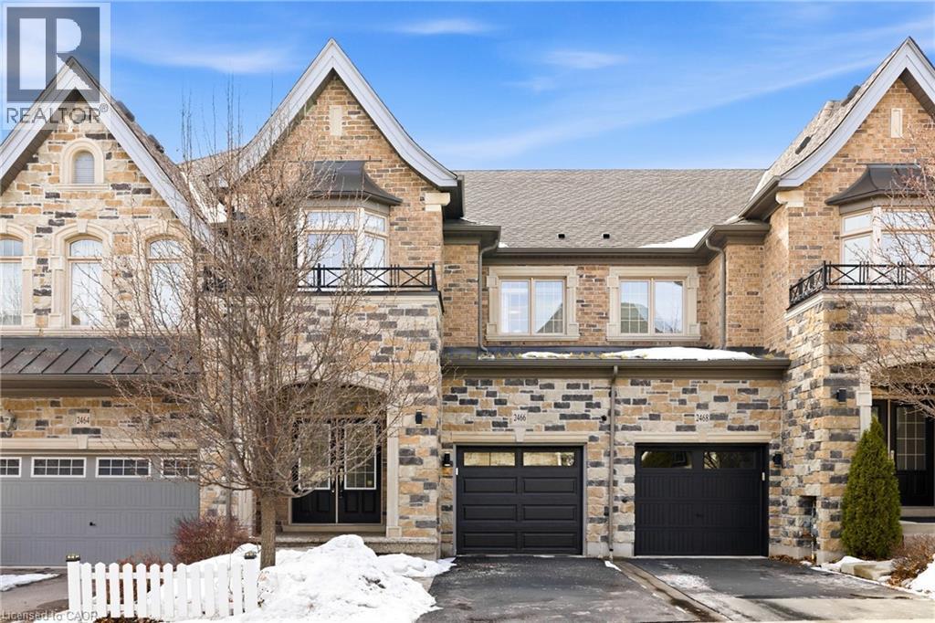 Stone and brick facade featuring multiple gables and a bay window with a wrought iron balcony - 2466 Village Common, Oakville, ON - Outdoor With Facade