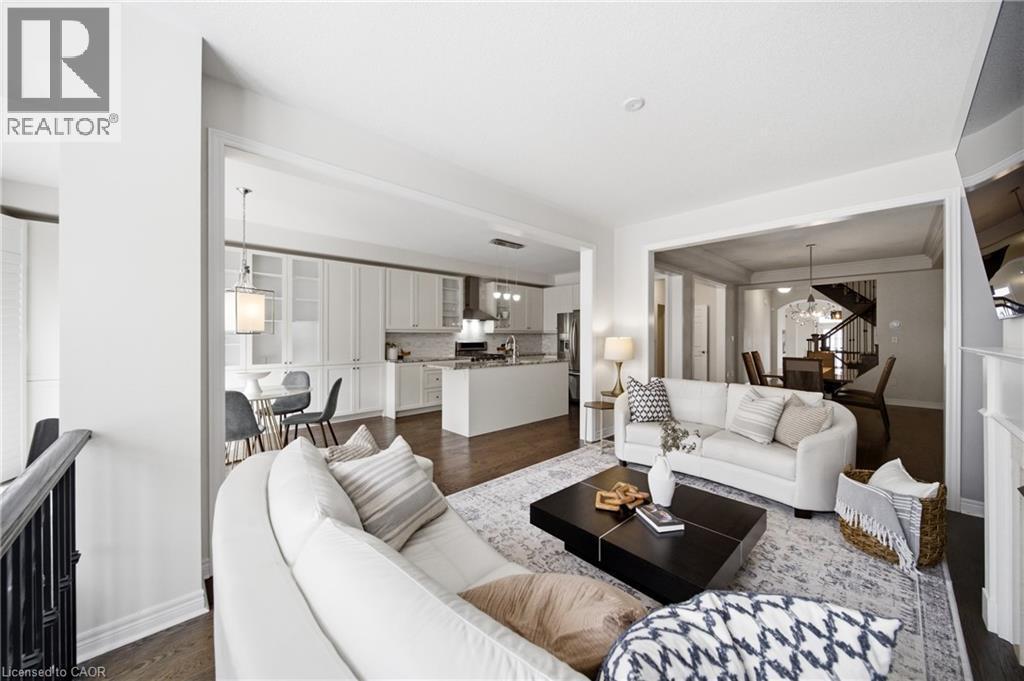 Expansive living area showcasing rich wood-finish flooring, white walls, and broad cased openings - 2466 Village Common, Oakville, ON - Indoor Photo Showing Living Room