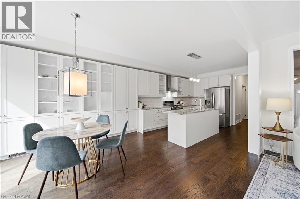 Open-concept kitchen and dining area featuring rich wood-finish flooring - 2466 Village Common, Oakville, ON - Indoor