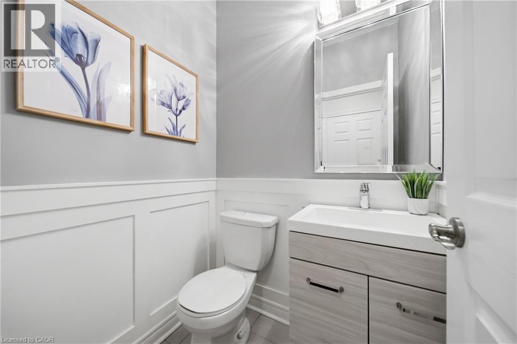 Bathroom featuring white wainscoting, a modern vanity with integrated sink, and an illuminated mirror - 2466 Village Common, Oakville, ON - Indoor Photo Showing Bathroom