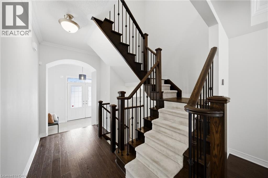 Dark wood-finish flooring extending through an arched entryway - 2466 Village Common, Oakville, ON - Indoor Photo Showing Other Room