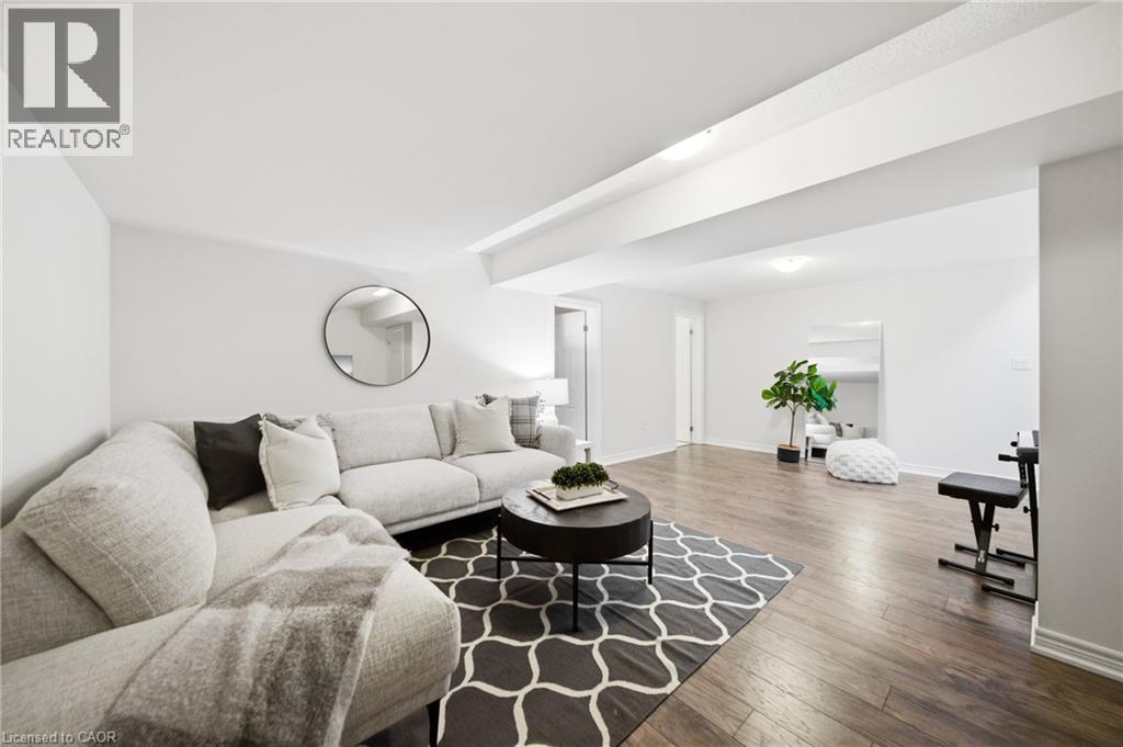 Lower level living space featuring wood-finish flooring, recessed lighting, and white painted walls - 2466 Village Common, Oakville, ON - Indoor Photo Showing Living Room