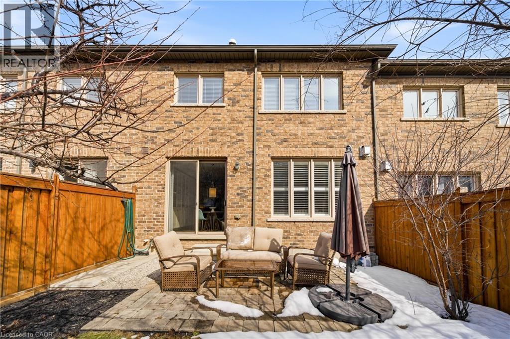 Brick exterior featuring multiple windows and a sliding glass door - 2466 Village Common, Oakville, ON - Outdoor