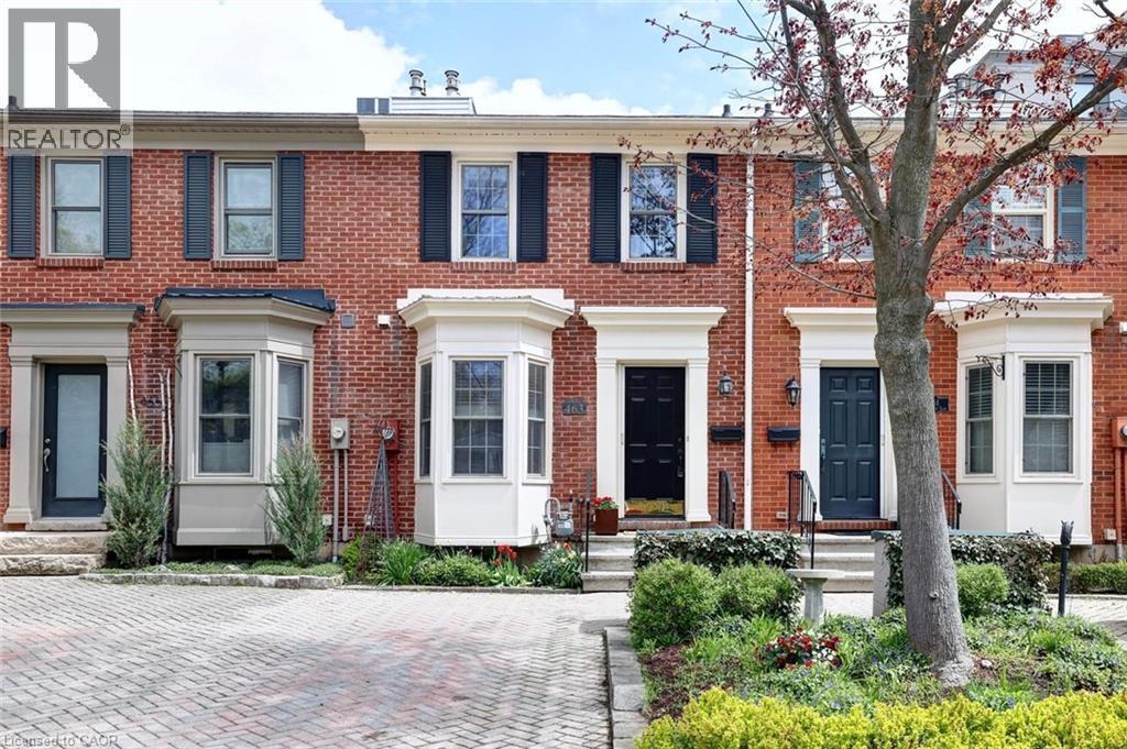 Brick facade townhome featuring bay windows, black shutters, and white trim accents - 463 Blathwayte Lane, Burlington, ON - Outdoor With Facade