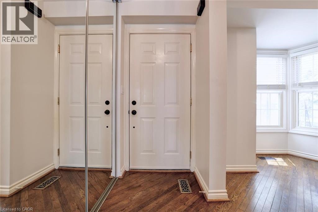 Entryway featuring warm wood-finish flooring and a full-length mirrored closet door - 463 Blathwayte Lane, Burlington, ON - Indoor Photo Showing Other Room