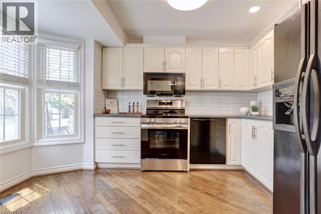 Kitchen featuring wood-finish flooring, white cabinetry, and stainless steel appliances - 463 Blathwayte Lane, Burlington, ON - Indoor Photo Showing Kitchen With Upgraded Kitchen