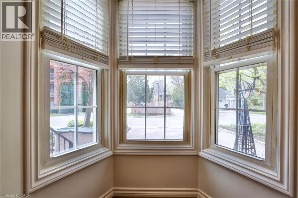Bay window featuring three large double-hung windows with white blinds, substantial decorative trim, and matching baseboards - 463 Blathwayte Lane, Burlington, ON - Indoor Photo Showing Other Room
