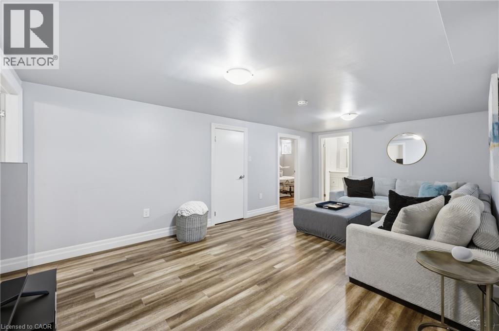 Spacious room featuring wood-finish flooring, light gray wall paint, and white trim - 168 Nugent Drive, Hamilton, ON - Indoor Photo Showing Living Room