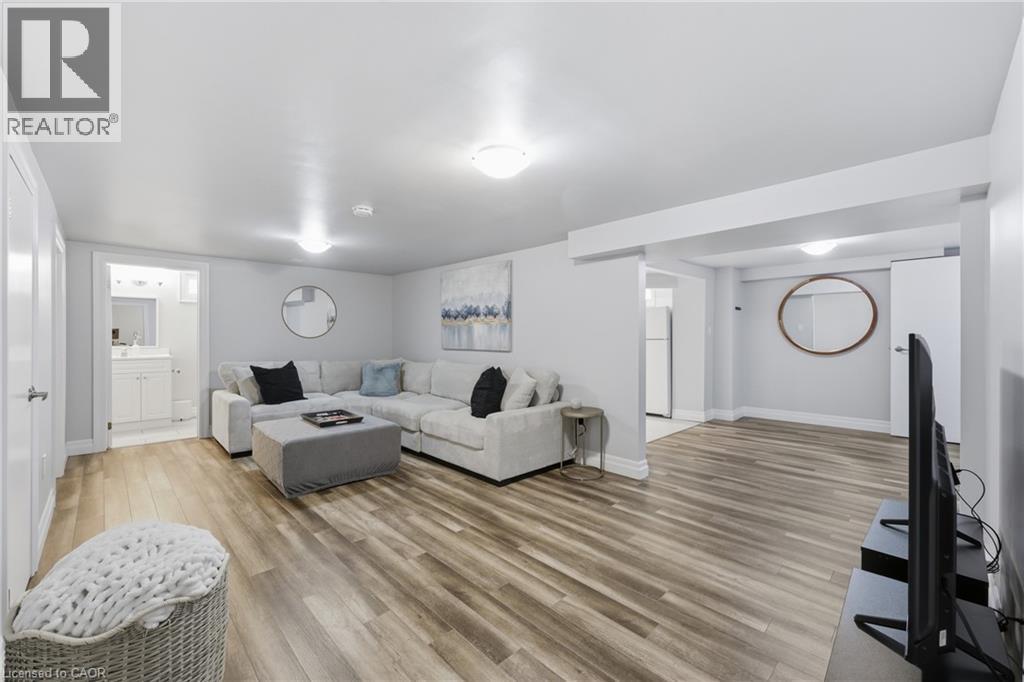 Open concept living area featuring wood-finish flooring, recessed lighting, and light gray wall tones - 168 Nugent Drive, Hamilton, ON - Indoor