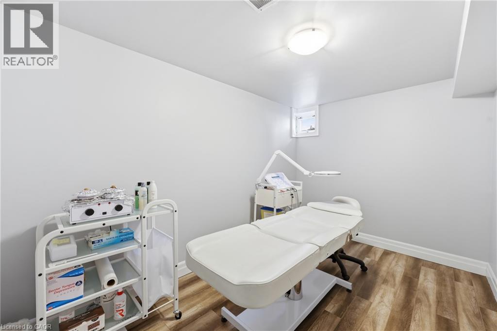 Room featuring wood-finish flooring, light grey walls, and white baseboards - 168 Nugent Drive, Hamilton, ON - Indoor