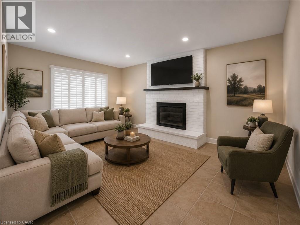 Living area featuring a white brick fireplace with a dark wood mantle, recessed lighting, and tile flooring - 16 Glennie Court, Cambridge, ON - Indoor Photo Showing Living Room With Fireplace
