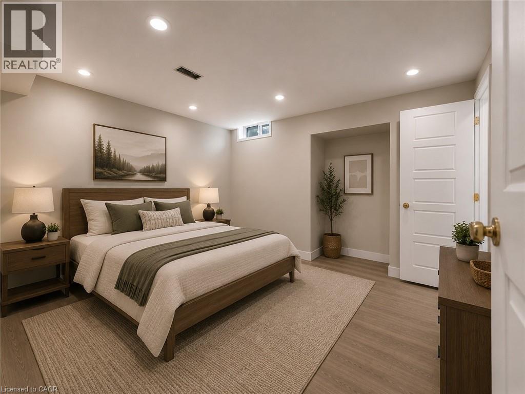 Spacious bedroom featuring wood-finish flooring, recessed lighting, a horizontal window, and a five-panel door with brass hardware - 16 Glennie Court, Cambridge, ON - Indoor Photo Showing Bedroom