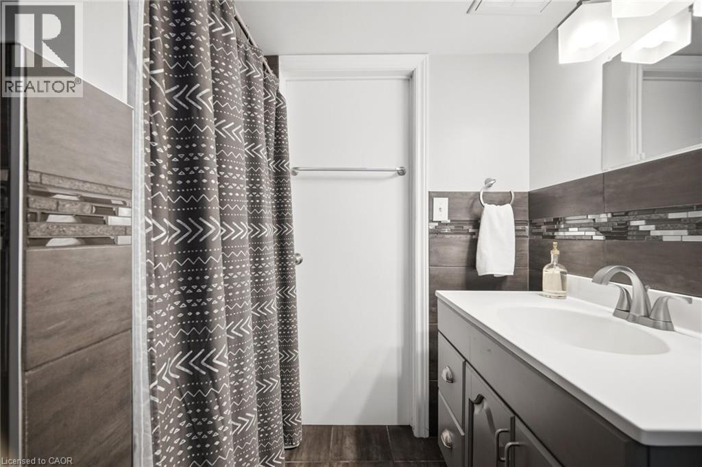 Bathroom featuring a vanity with an integrated sink, brushed nickel faucet, and under-sink cabinetry - 94 Clarendon Avenue, Hamilton, ON - Indoor Photo Showing Bathroom