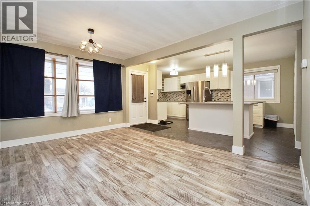 Open-concept living area with wood-finish flooring, a modern chandelier, and recessed lighting - 61 Bosworth Crescent Unit# Upper, Kitchener, ON - Indoor