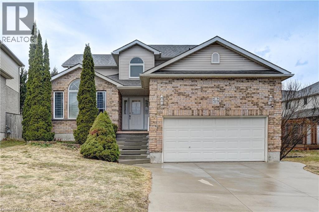 Brick veneer and siding exterior featuring a two-car garage, concrete driveway, and established front landscaping - 519 Yorkshire Drive, Waterloo, ON - Outdoor With Facade