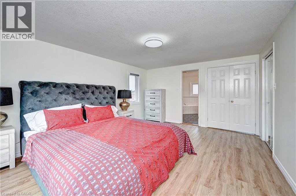 Spacious room featuring wood-finish flooring, white walls, and a recessed window - 519 Yorkshire Drive, Waterloo, ON - Indoor Photo Showing Bedroom