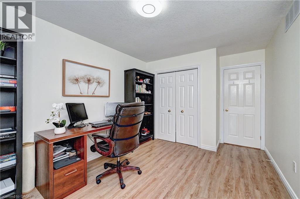 Neutral wall paint, wood-finish flooring, white trim, and a flush mount ceiling light fixture - 519 Yorkshire Drive, Waterloo, ON - Indoor Photo Showing Office