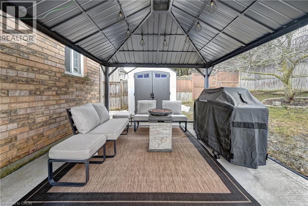 Covered concrete patio featuring a metal gazebo, string lighting, and an outdoor area rug - 519 Yorkshire Drive, Waterloo, ON - Outdoor With Deck Patio Veranda With Exterior