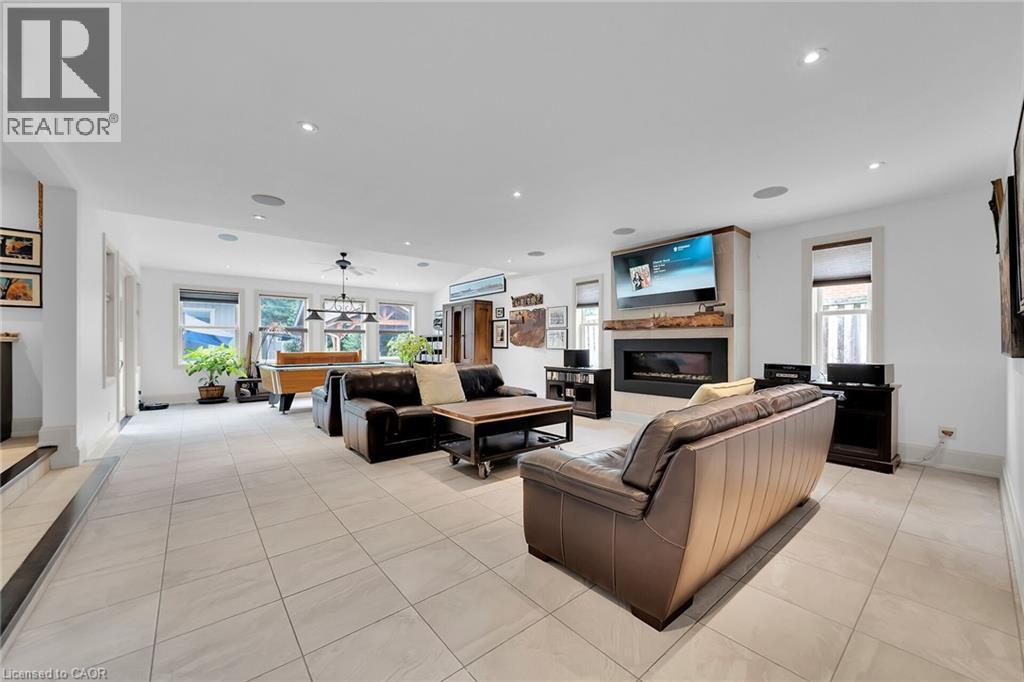 Living room with a glass covered fireplace, light tile patterned flooring, billiards, and recessed lighting - 404 Mountain Brow Boulevard E, Hamilton, ON - Indoor With Fireplace