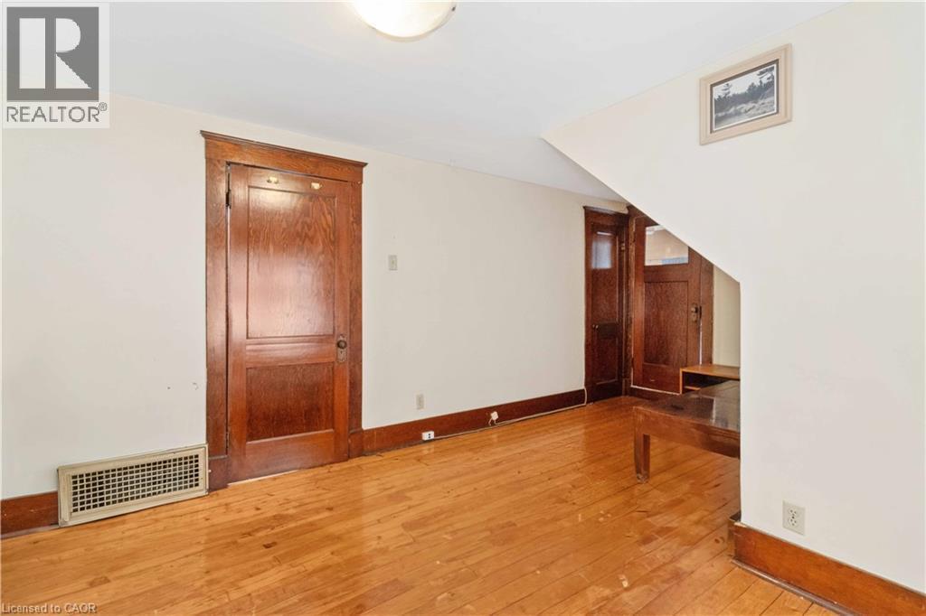 Hardwood flooring complemented by white walls - 151 Louisa Street, Kitchener, ON - Indoor Photo Showing Other Room