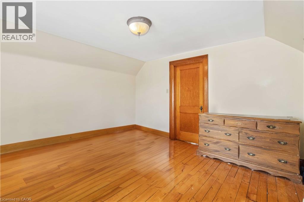 Hardwood flooring, painted walls, wood trim, and a ceiling-mounted light fixture - 151 Louisa Street, Kitchener, ON - Indoor Photo Showing Other Room