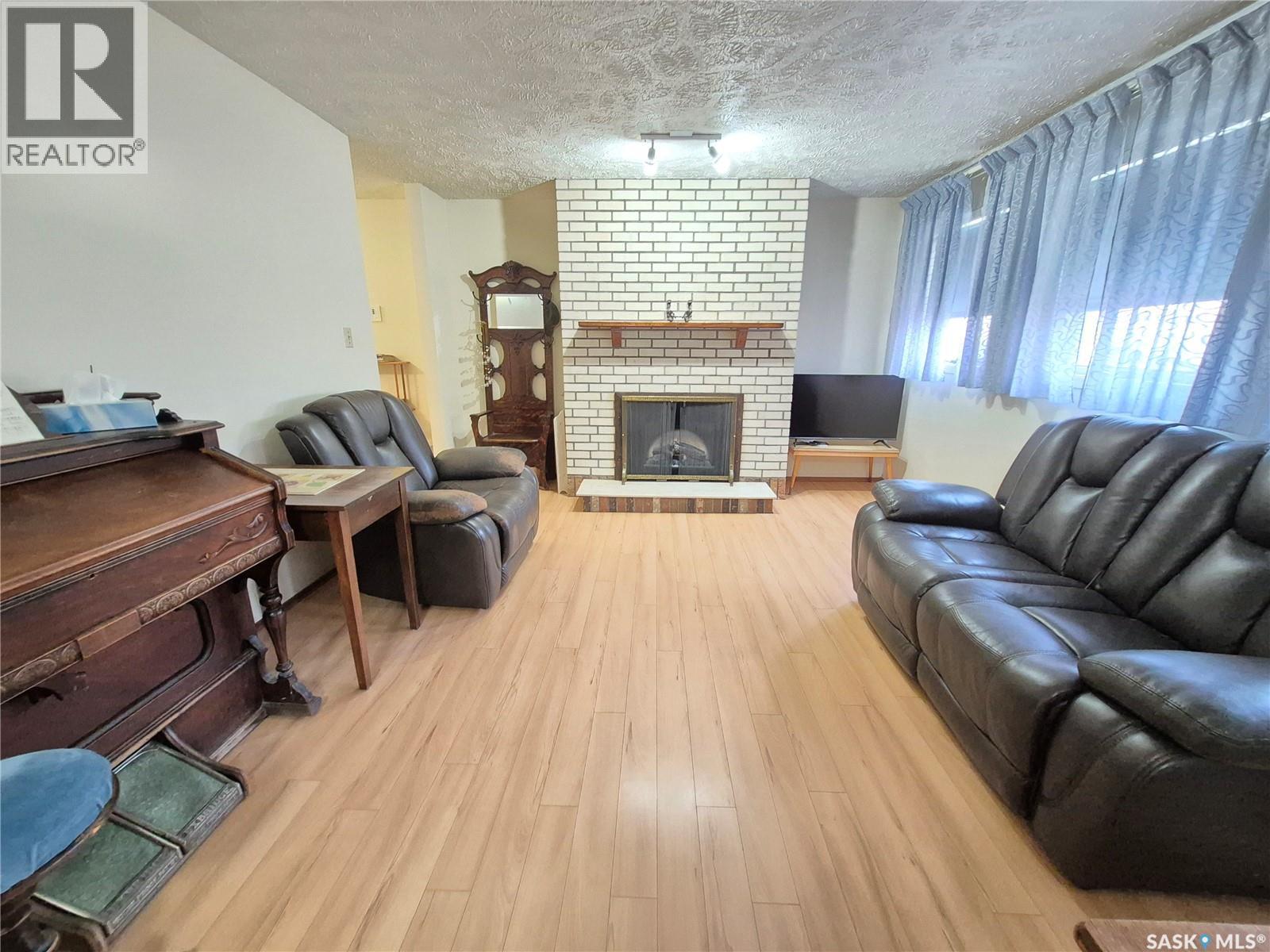 16 228 3Rd Street, Weyburn, SK - Indoor Photo Showing Living Room With Fireplace