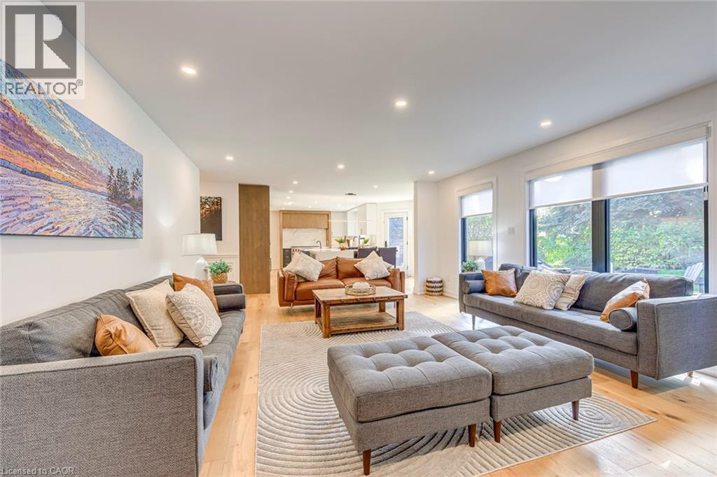 Bright interior featuring recessed lighting and large windows with privacy shades - 54 Deerview Avenue, Ancaster, ON - Indoor Photo Showing Living Room