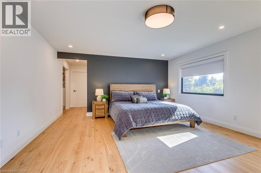 Spacious room featuring light wood-finish flooring, recessed lighting, and a modern drum ceiling fixture - 54 Deerview Avenue, Ancaster, ON - Indoor Photo Showing Bedroom