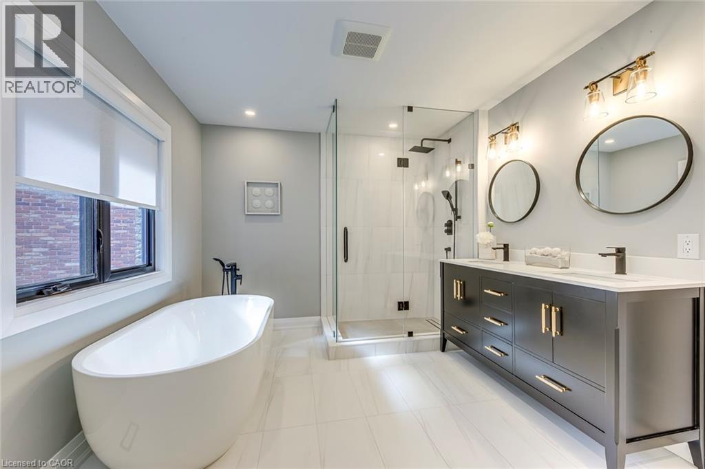Contemporary bathroom featuring a freestanding soaking tub with matte black fixtures - 54 Deerview Avenue, Ancaster, ON - Indoor Photo Showing Bathroom