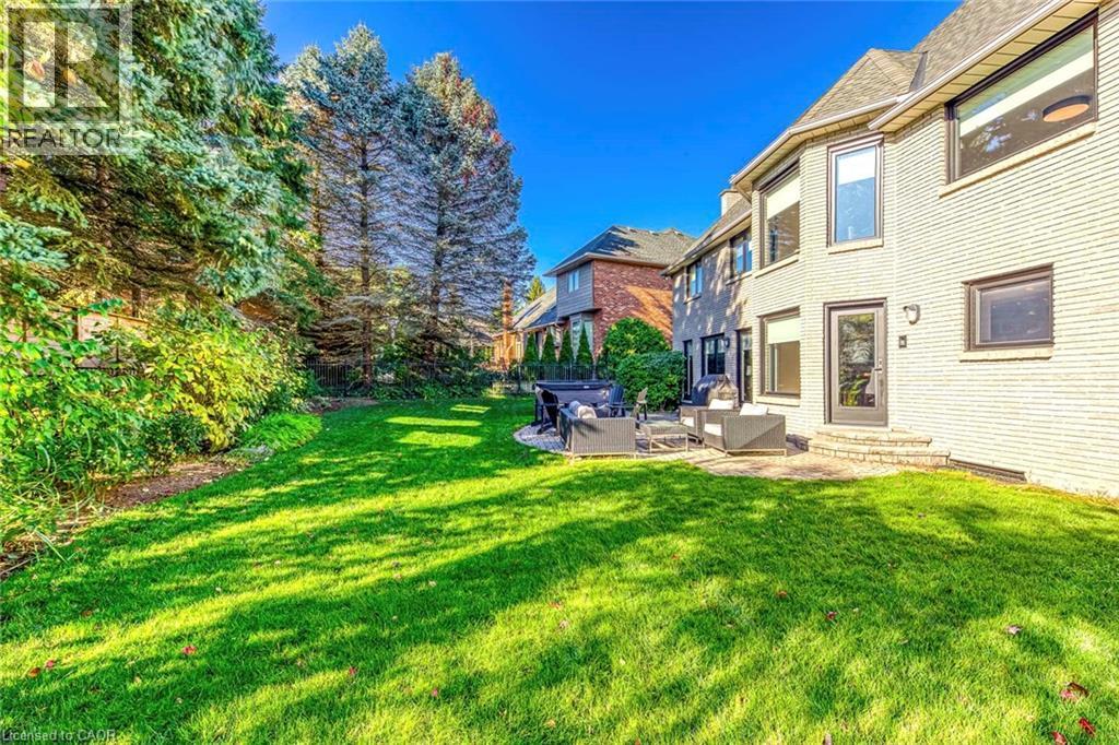Expansive rear yard featuring a manicured lawn and mature perimeter trees - 54 Deerview Avenue, Ancaster, ON - Outdoor