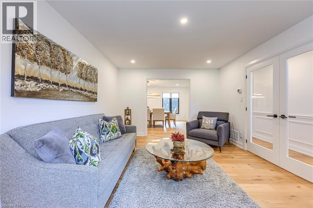 Living area with light wood-finish flooring, recessed lighting, and white walls - 54 Deerview Avenue, Ancaster, ON - Indoor Photo Showing Living Room
