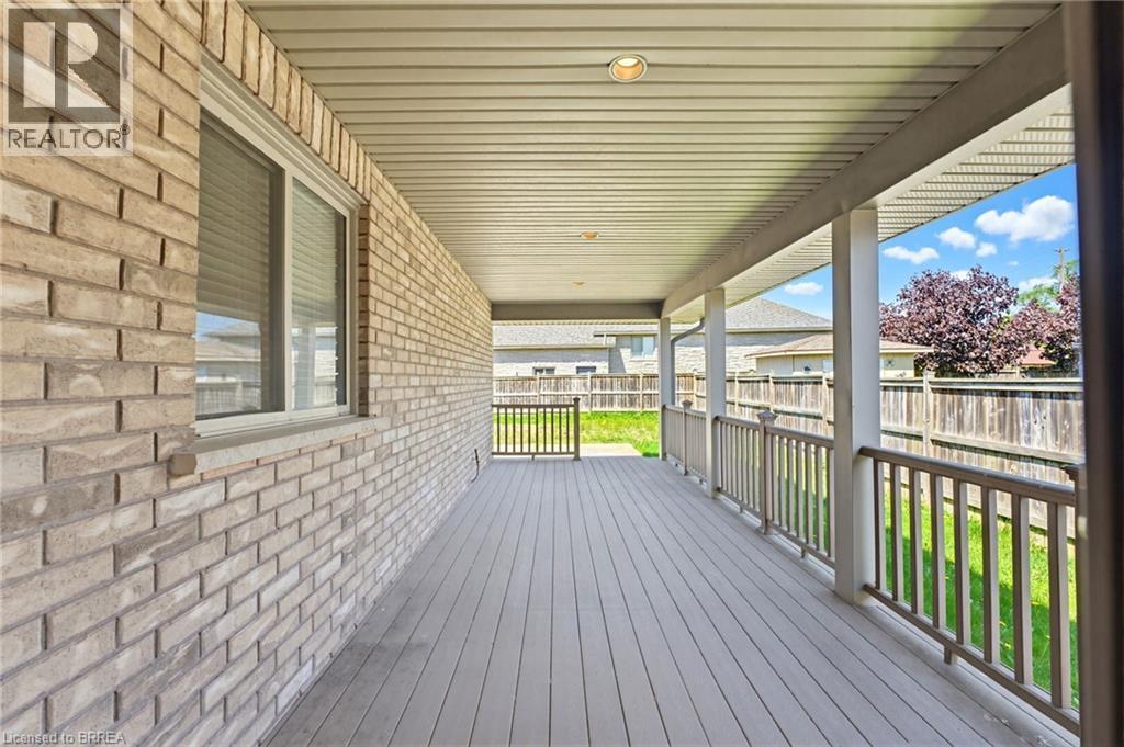 Expansive covered deck featuring composite wood-finish decking, white vinyl railings, and a recessed ceiling light - 6 General Street, Brantford, ON - Outdoor With Deck Patio Veranda With Exterior