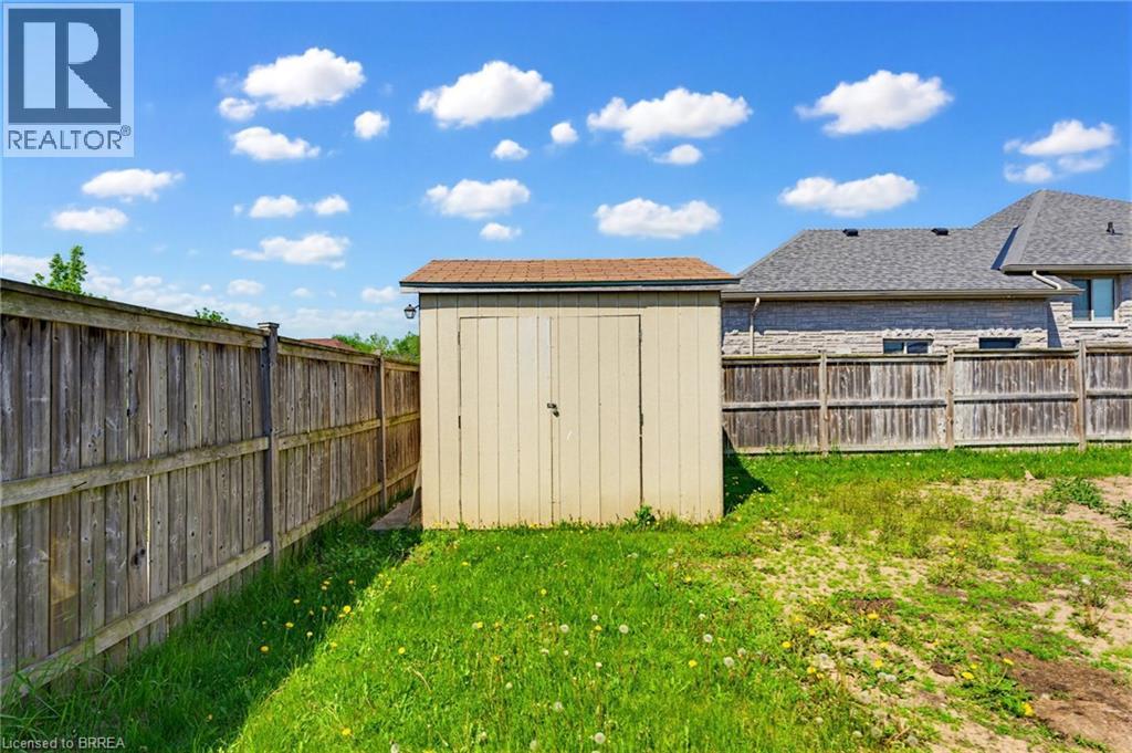 Enclosed backyard featuring a wooden storage shed with an asphalt shingle roof - 6 General Street, Brantford, ON - Outdoor