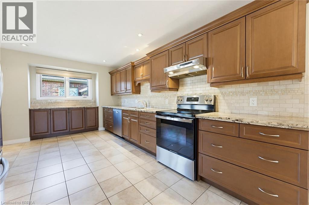 Kitchen featuring extensive cabinetry, tile flooring, stainless steel appliances, granite countertops, and a subway tile backsplash - 6 General Street, Brantford, ON - Indoor Photo Showing Kitchen