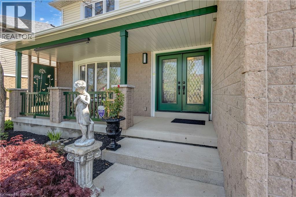 Covered front porch featuring a decorative screen panel, green railings, and a bay window - 69 Hunter Way, Brantford, ON - Outdoor With Deck Patio Veranda With Exterior