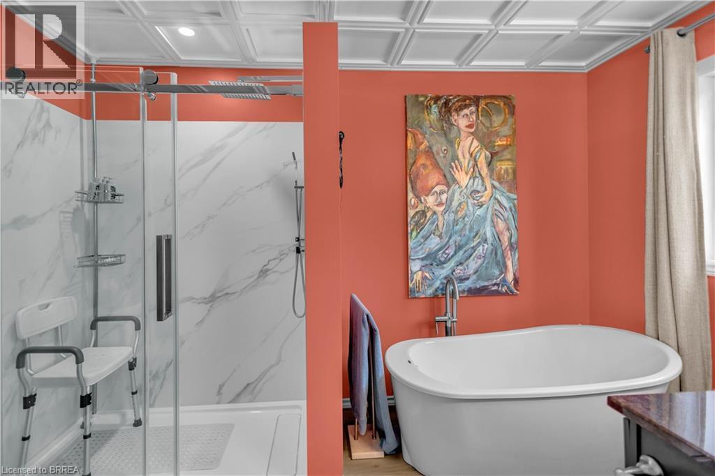 Freestanding soaking tub complemented by a separate glass-enclosed shower with white marble-look paneling - 69 Hunter Way, Brantford, ON - Indoor Photo Showing Bathroom