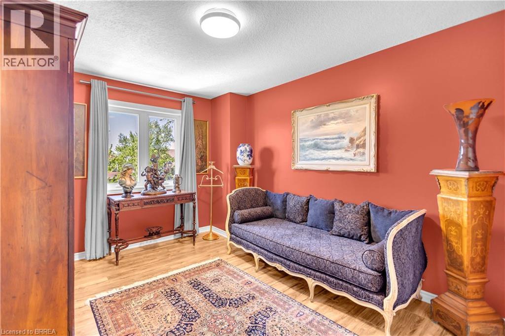 Vibrant interior space featuring wood-finish flooring, a window with grey curtains, and a flush-mount ceiling light - 69 Hunter Way, Brantford, ON - Indoor Photo Showing Living Room