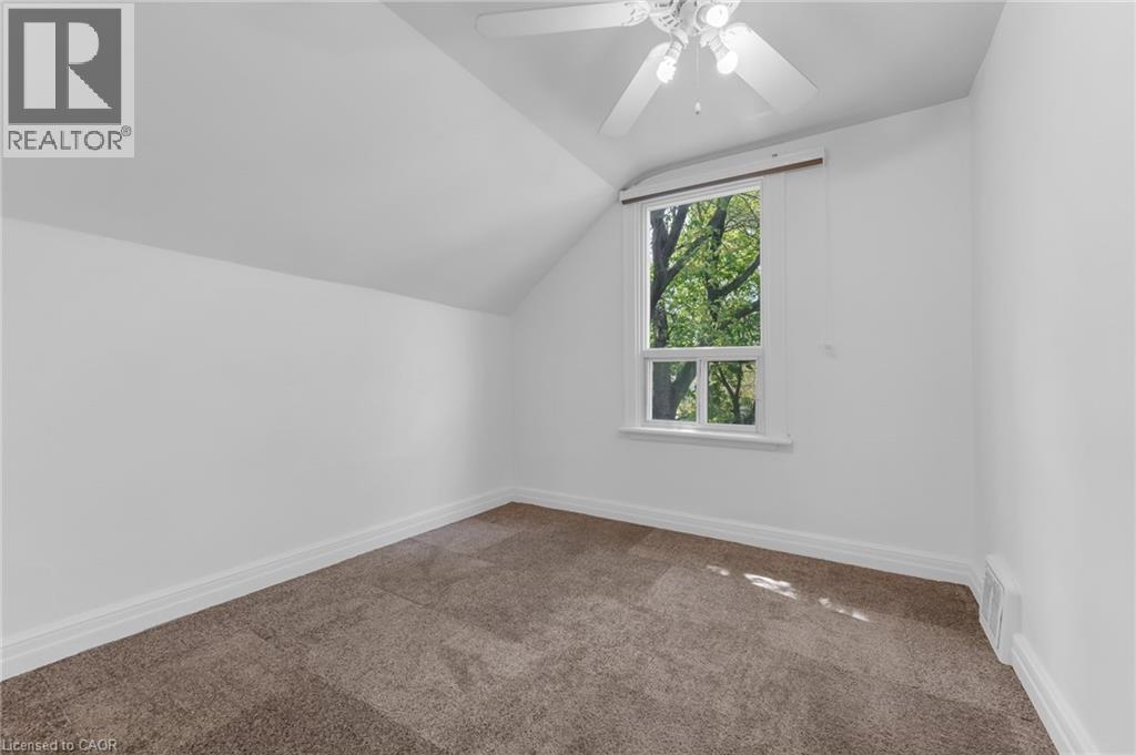 Attic room featuring a single window with white trim, sloped ceiling, light-colored walls, and brown carpeting - 168 Britannia Avenue, Hamilton, ON - Indoor Photo Showing Other Room
